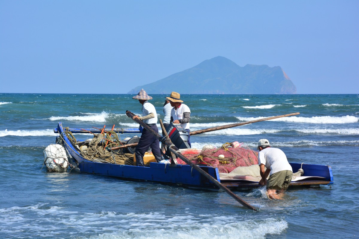 小さい漁船がこの網を引いて海上をめぐり、もう一端を岸辺の人に渡し