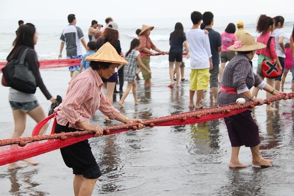 舢舨駛向魚群密集靠處將罟網撒到海裡,等到魚群被圍住…