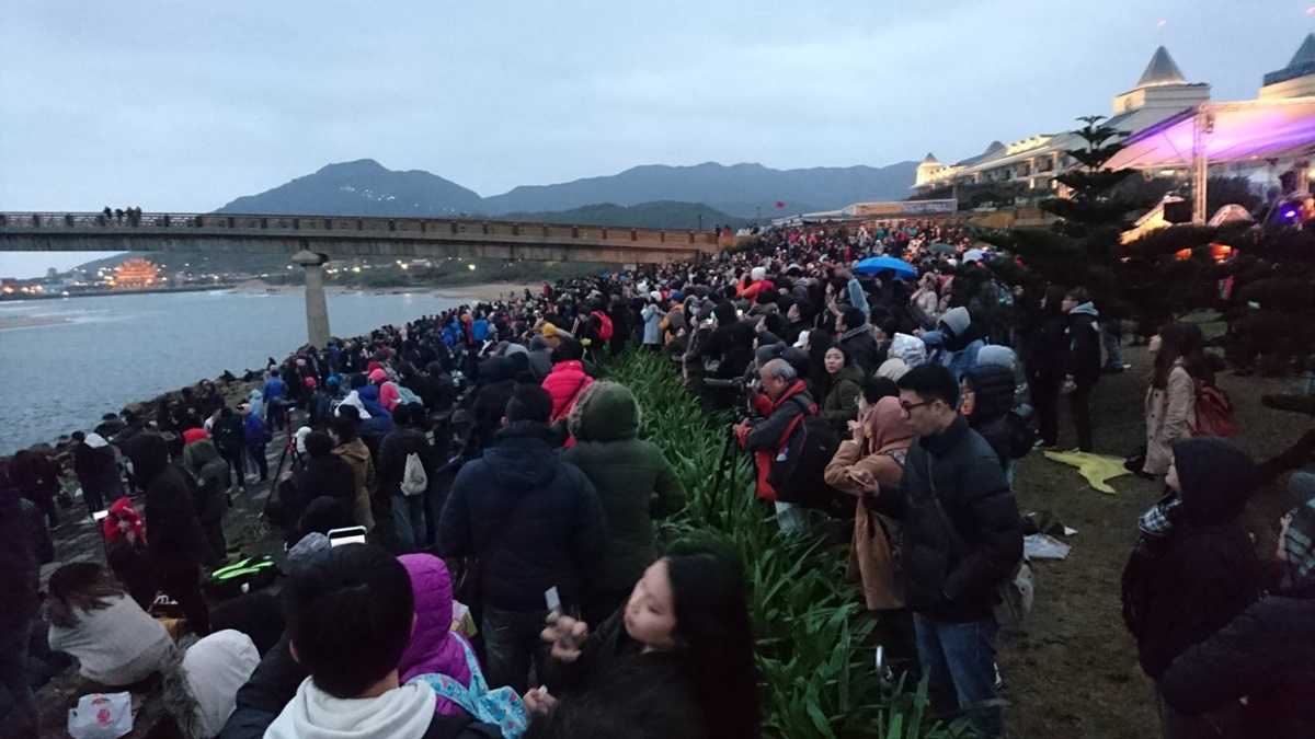 2018 Fulong Yingguang 관광객들은 Rainbow Bridge 옆에서 새벽을 기다립니다.